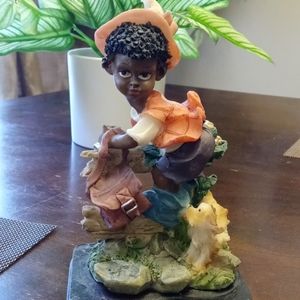 Child climbing a fence with dog Figurine